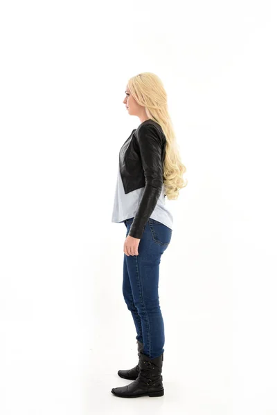 シンプルなジーンズと革のジャケットを身に着けている女の子の完全な長さの肖像画 立ちポーズ カメラから離れて直面しています ホワイト スタジオの背景に分離 — ストック写真