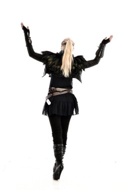 tam uzunlukta yırtık portre sarışın kız giyiyor siyah tüy kostüm. arka beyaz arka plan üzerinde izole kamera ile ayakta poz.