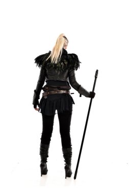 tam uzunlukta portre sarışın kız siyah yırtık kıyafeti giymiş bir personel'ın elinde. ayakta poz, beyaz stüdyo arka plan üzerinde izole.