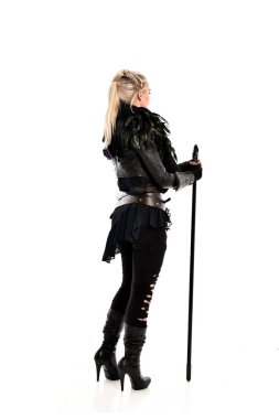 tam uzunlukta portre sarışın kız siyah yırtık kıyafeti giymiş bir personel tutarak. ayakta poz geri gönderin. beyaz stüdyo arka plan üzerinde izole.