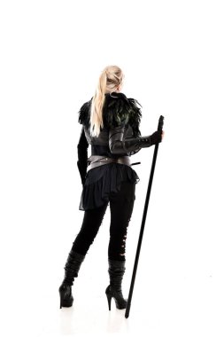 tam uzunlukta portre sarışın kız siyah yırtık kıyafeti giymiş bir personel tutarak. ayakta poz geri gönderin. beyaz stüdyo arka plan üzerinde izole.