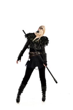 tam uzunlukta portre sarışın kız siyah yırtık kıyafeti giymiş bir personel tutarak. ayakta poz geri gönderin. beyaz stüdyo arka plan üzerinde izole.