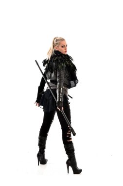 tam uzunlukta portre sarışın kız siyah yırtık kıyafeti giymiş bir personel tutarak. ayakta poz geri gönderin. beyaz stüdyo arka plan üzerinde izole.