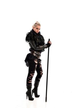 tam uzunlukta portre sarışın kız siyah yırtık kıyafeti giymiş bir personel'ın elinde. ayakta poz, beyaz stüdyo arka plan üzerinde izole.