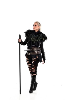 tam uzunlukta portre sarışın kız siyah yırtık kıyafeti giymiş bir personel'ın elinde. ayakta poz, beyaz stüdyo arka plan üzerinde izole.