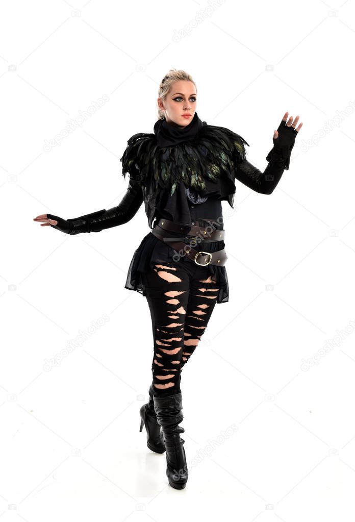 full length portrait of blonde girl wearing black, torn gothic outfit. standing pose, isolated on white studio background.