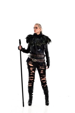 tam uzunlukta portre sarışın kız siyah yırtık kıyafeti giymiş bir personel'ın elinde. ayakta poz, beyaz stüdyo arka plan üzerinde izole.