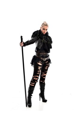 tam uzunlukta portre sarışın kız siyah yırtık kıyafeti giymiş bir personel'ın elinde. ayakta poz, beyaz stüdyo arka plan üzerinde izole.