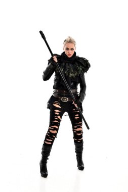 tam uzunlukta portre sarışın kız siyah yırtık kıyafeti giymiş bir personel'ın elinde. ayakta poz, beyaz stüdyo arka plan üzerinde izole.