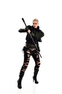 tam uzunlukta portre sarışın kız siyah yırtık kıyafeti giymiş bir personel'ın elinde. ayakta poz, beyaz stüdyo arka plan üzerinde izole.
