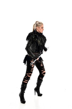 tam uzunlukta portre sarışın kız siyah yırtık kıyafeti giymiş bir personel'ın elinde. ayakta poz, beyaz stüdyo arka plan üzerinde izole.