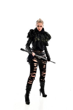 tam uzunlukta portre sarışın kız siyah yırtık kıyafeti giymiş bir personel'ın elinde. ayakta poz, beyaz stüdyo arka plan üzerinde izole.