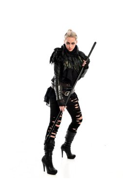 tam uzunlukta portre sarışın kız siyah yırtık kıyafeti giymiş bir personel'ın elinde. ayakta poz, beyaz stüdyo arka plan üzerinde izole.