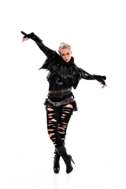 tam uzunlukta portre sarışın kız siyah yırtık kıyafeti giymiş bir personel'ın elinde. ayakta poz, beyaz stüdyo arka plan üzerinde izole.