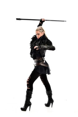 tam uzunlukta portre sarışın kız siyah yırtık kıyafeti giymiş bir personel'ın elinde. ayakta poz, beyaz stüdyo arka plan üzerinde izole.