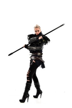 tam uzunlukta portre sarışın kız siyah yırtık kıyafeti giymiş bir personel'ın elinde. ayakta poz, beyaz stüdyo arka plan üzerinde izole.