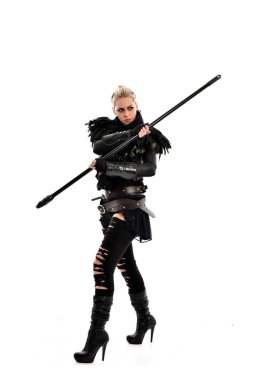 tam uzunlukta portre sarışın kız siyah yırtık kıyafeti giymiş bir personel'ın elinde. ayakta poz, beyaz stüdyo arka plan üzerinde izole.