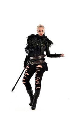 tam uzunlukta portre sarışın kız siyah yırtık kıyafeti giymiş bir personel'ın elinde. ayakta poz, beyaz stüdyo arka plan üzerinde izole.