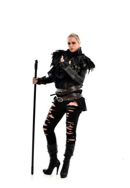 tam uzunlukta portre sarışın kız siyah yırtık kıyafeti giymiş bir personel'ın elinde. ayakta poz, beyaz stüdyo arka plan üzerinde izole.