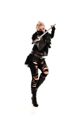 tam uzunlukta portre sarışın kız siyah yırtık kıyafeti giymiş bir personel'ın elinde. ayakta poz, beyaz stüdyo arka plan üzerinde izole.