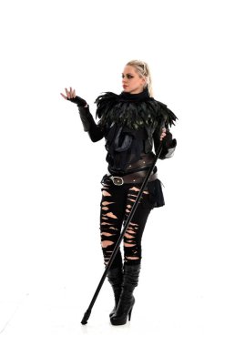 tam uzunlukta portre sarışın kız siyah yırtık kıyafeti giymiş bir personel'ın elinde. ayakta poz, beyaz stüdyo arka plan üzerinde izole.