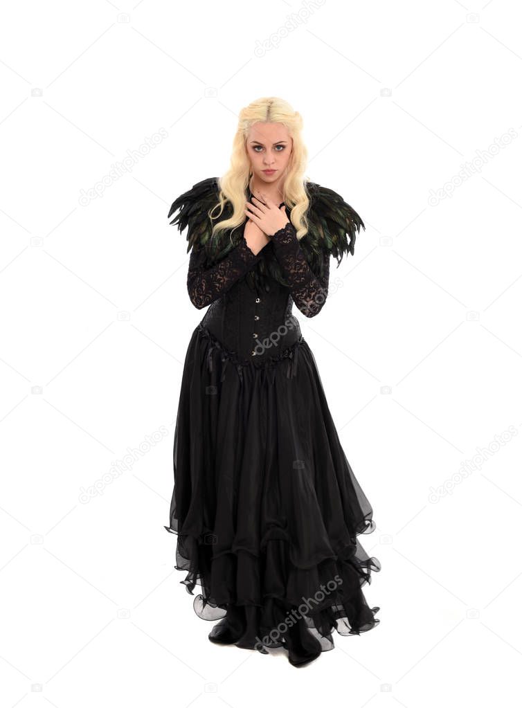 full length portrait of blonde girl wearing corset and long black gown. isolated on white studio background,