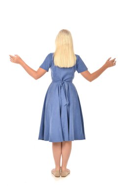 tam uzunlukta portre sarışın kız mavi elbise giyiyor. ayakta poz geri gönderin. beyaz stüdyo arka plan üzerinde izole.