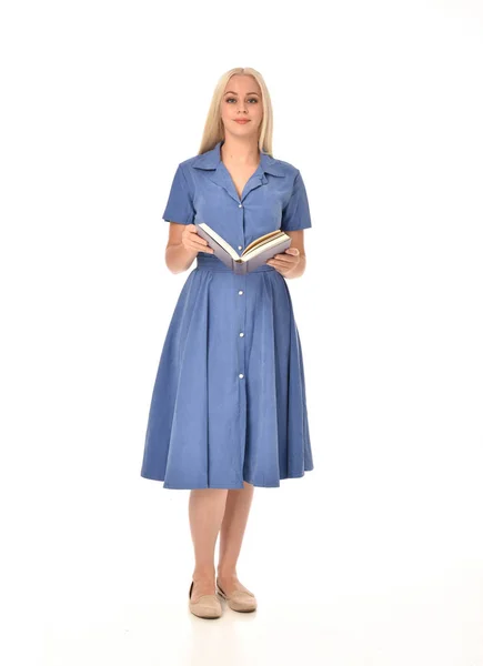 青いドレスを着ている金髪の女の子の完全な長さの肖像画 本を持って立ちポーズ ホワイト スタジオの背景に分離 — ストック写真