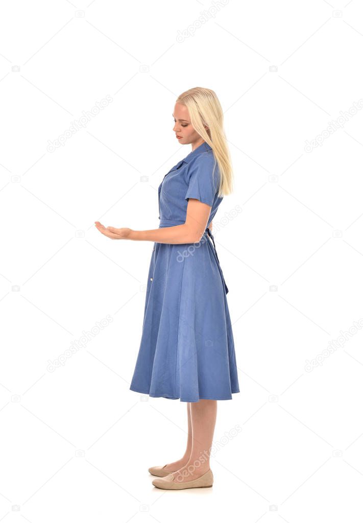 full length portrait of blonde girl wearing blue dress, standing pose. isolated on white  studio background.