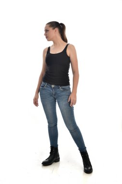 Tam boy siyah tek ve kot giyen esmer kız portresi. poz ayakta. beyaz stüdyo arka plan üzerinde izole.