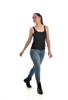 Tam boy siyah tek ve kot giyen esmer kız portresi. poz ayakta. beyaz stüdyo arka plan üzerinde izole.