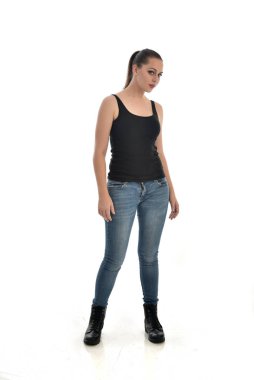 Tam boy siyah tek ve kot giyen esmer kız portresi. poz ayakta. beyaz stüdyo arka plan üzerinde izole.