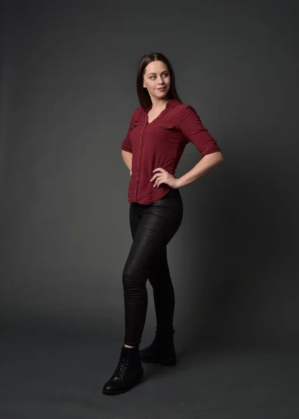 full length portrait of a pretty brunette girl wearing a red shirt