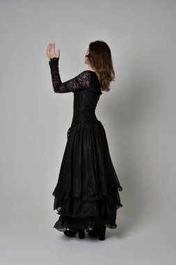 Tam boy esmer kız uzun siyah dantel elbise zekâ korse giymek portresi. ayakta poz geri gönderin. gri studio arka plan üzerinde izole.
