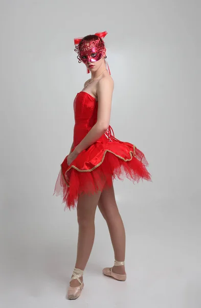 穿红色芭蕾舞衣和面具的女孩的全长肖像 在工作室背景上跳舞姿势 — 图库照片