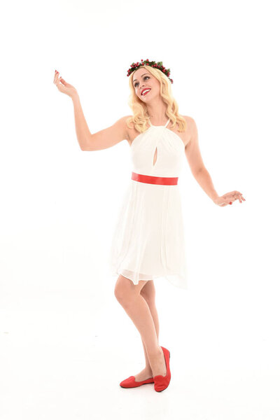 полноразмерный портрет блондинки в белом платье и цветочной короне. Стоя поза, держа красный подарок, изолированы на белом фоне студии
.