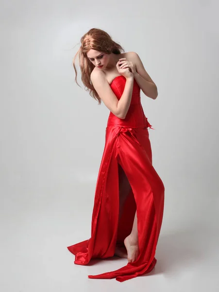 Портрет Девушки Длинном Красном Шелковом Платье Стоящей Позе Сером Фоне — стоковое фото