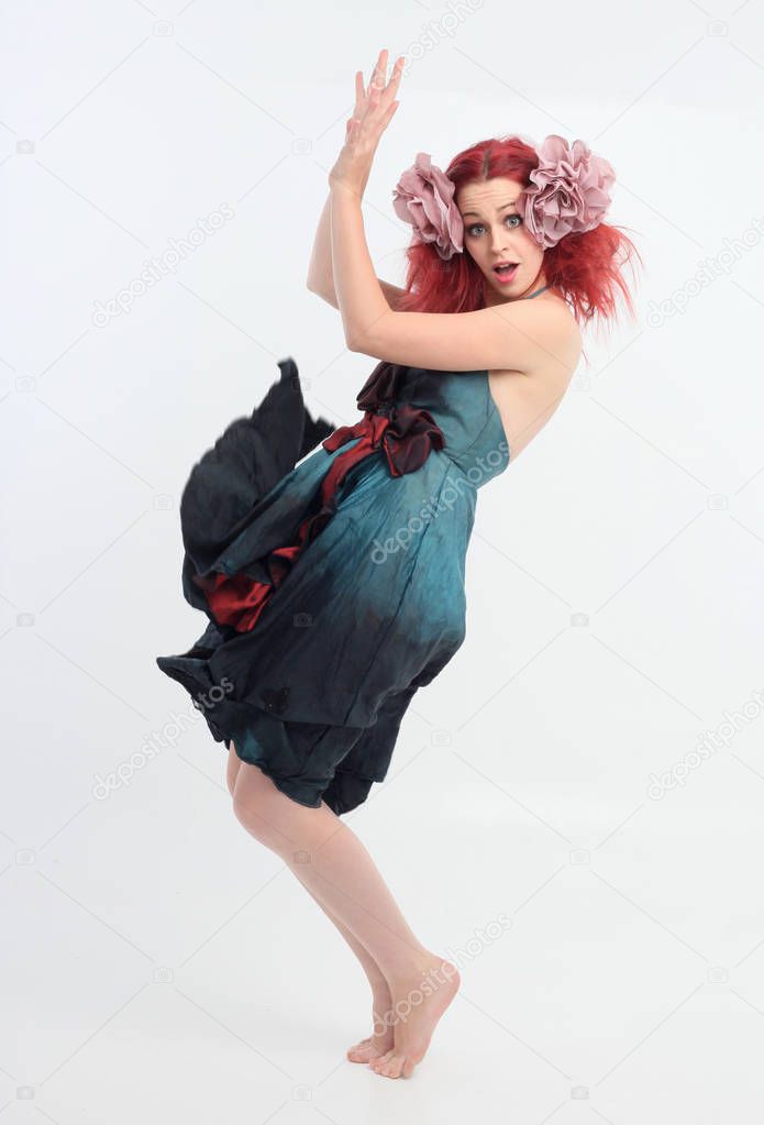 full length portrait of red haired girl wearing fairy costume, posing on a white studio background.