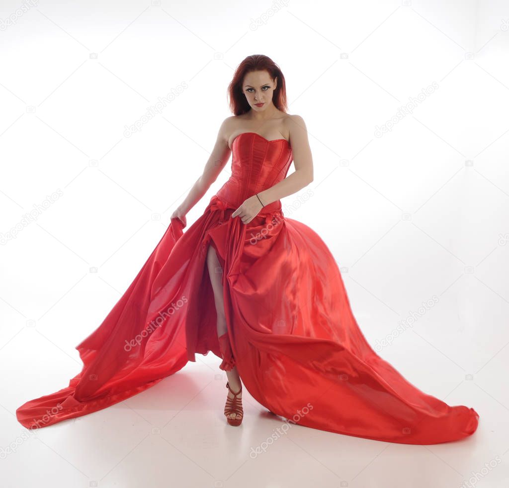 full length portrait of woman wearing red riding hook cloak and long silk gown. standing pose, isolated on white studio background