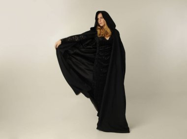 kravat ve ekose etek ile kırmızı hırka giyen sarışın kız tam uzunlukta portre, okul üniforması, beyaz bir stüdyo arka plan üzerinde, kameradan uzağa bakan poz ayakta.