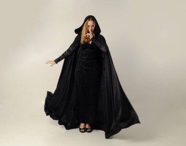 kravat ve ekose etek ile kırmızı hırka giyen sarışın kız tam uzunlukta portre, okul üniforması, beyaz bir stüdyo arka plan üzerinde, kameradan uzağa bakan poz ayakta.