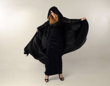 kravat ve ekose etek ile kırmızı hırka giyen sarışın kız tam uzunlukta portre, okul üniforması, beyaz bir stüdyo arka plan üzerinde, kameradan uzağa bakan poz ayakta.