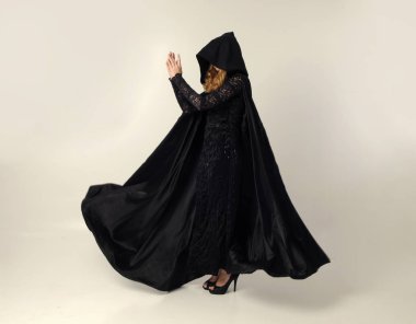 kravat ve ekose etek ile kırmızı hırka giyen sarışın kız tam uzunlukta portre, okul üniforması, beyaz bir stüdyo arka plan üzerinde, kameradan uzağa bakan poz ayakta.