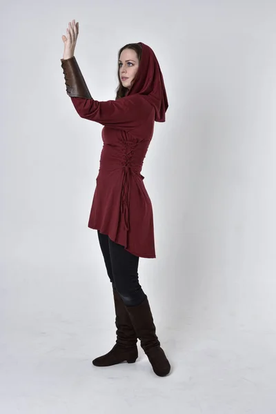 一个黑发女孩的全长肖像 穿着红色幻想服 头戴头巾 站在白色工作室背景的侧写上的姿势 — 图库照片