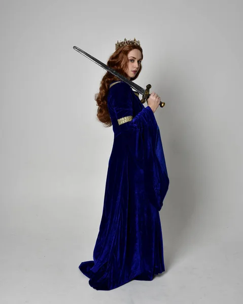 파란색 가운을 왕관을 소녀의 초상화 스튜디오 배경에 자세로 — 스톡 사진