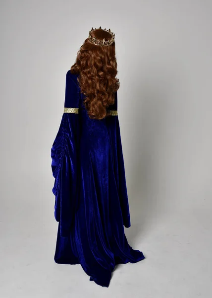 파란색 가운을 왕관을 소녀의 전체긴 초상화 스튜디오 배경에 카메라 앞으로 — 스톡 사진