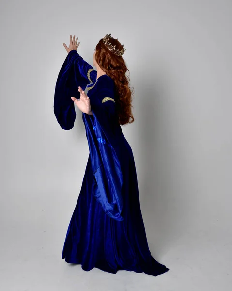 파란색 가운을 왕관을 소녀의 전체긴 초상화 스튜디오 배경에 카메라 앞으로 — 스톡 사진