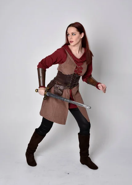 中世の衣装を着た少女の完全な長さの肖像画 灰色のスタジオの背景に隔離された剣を保持する立ちポーズ — ストック写真