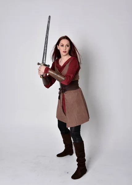 中世の衣装を着た少女の完全な長さの肖像画 灰色のスタジオの背景に隔離された剣を保持する立ちポーズ — ストック写真
