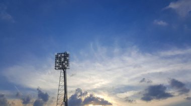Yüksek güç spot, gökyüzü ve bulutlar ile açık stadyum.